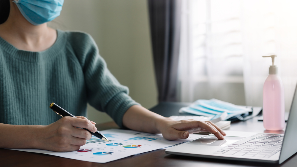 Women accounting while wearing a mask