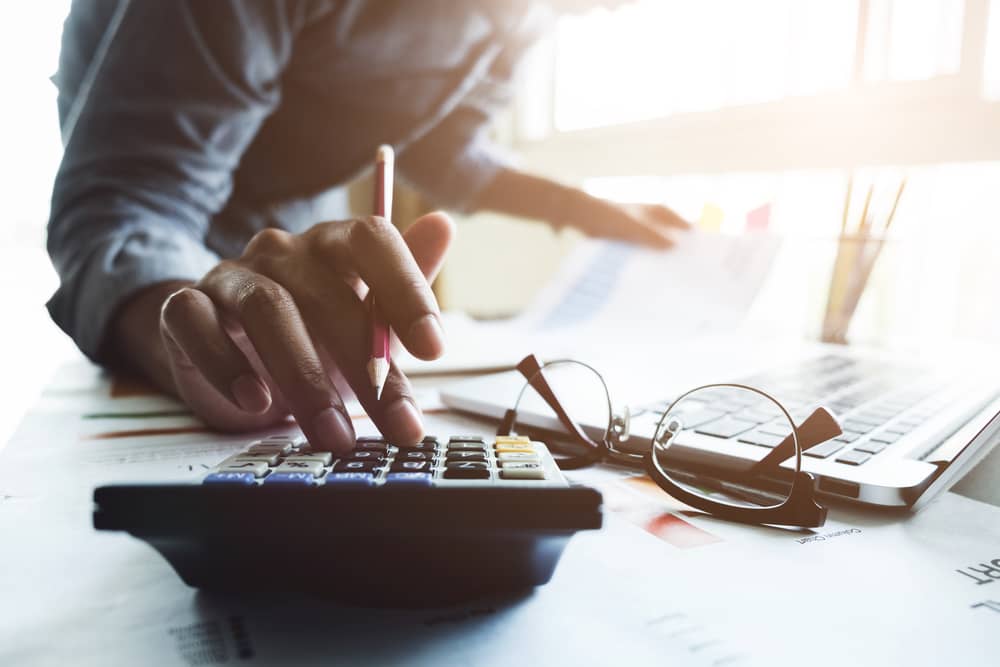 A man uses a calculator whilst working.