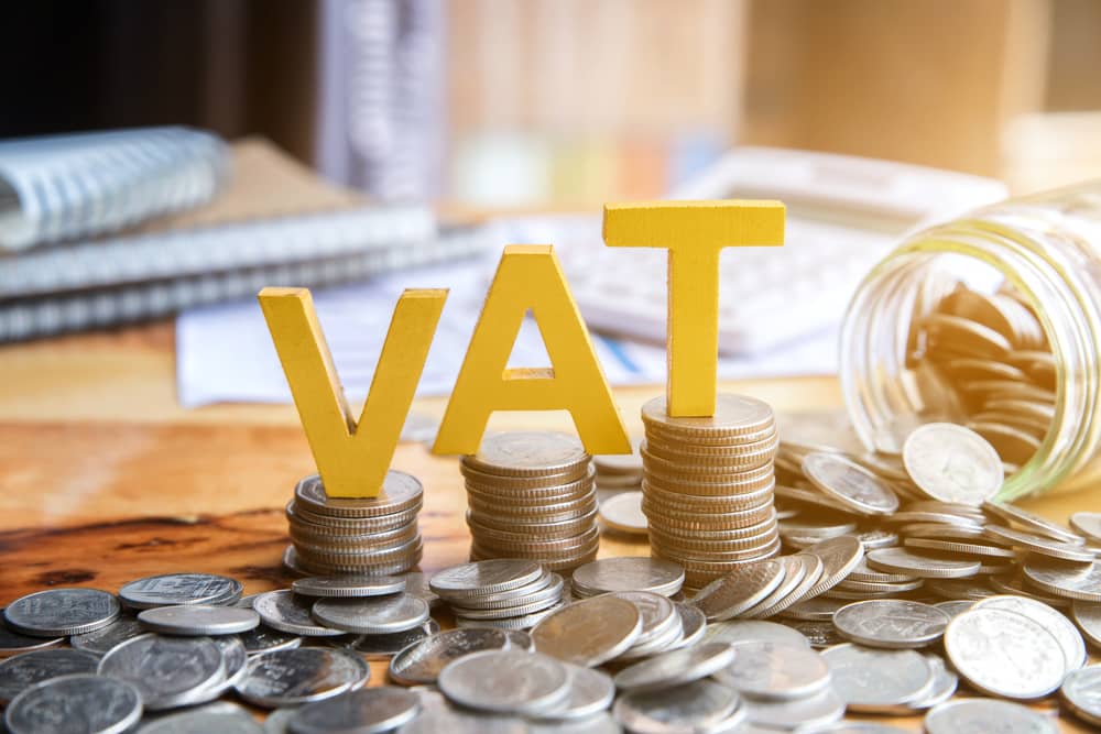 Yellow VAT letters on stacks of coins.