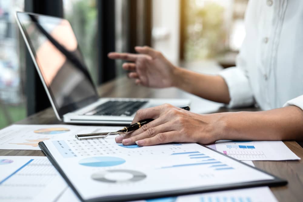 A woman works on laptop with charts.