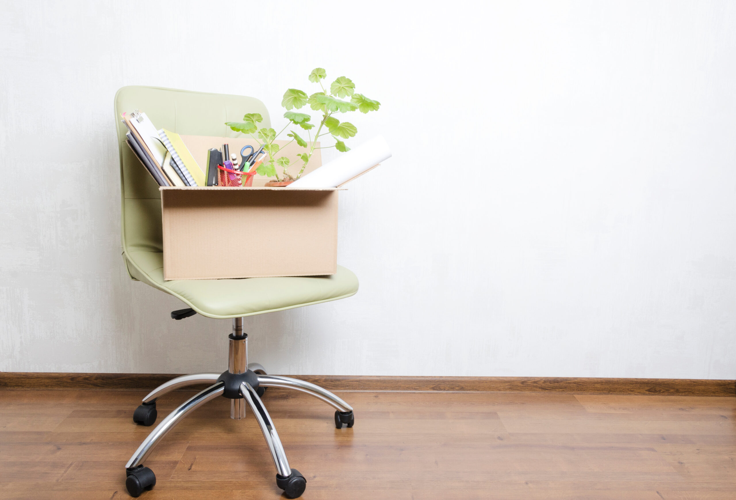 Box of personal belongings on office chair.