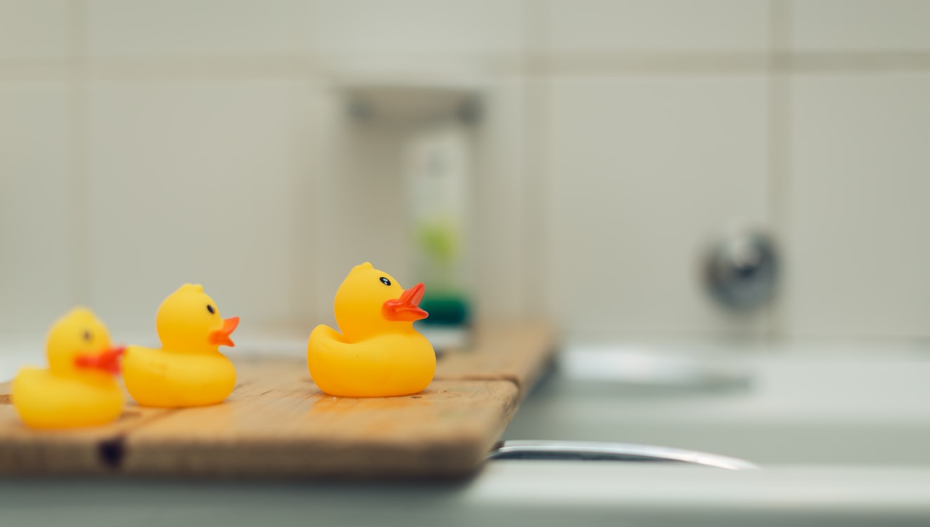 Rubber ducks on bath stand.