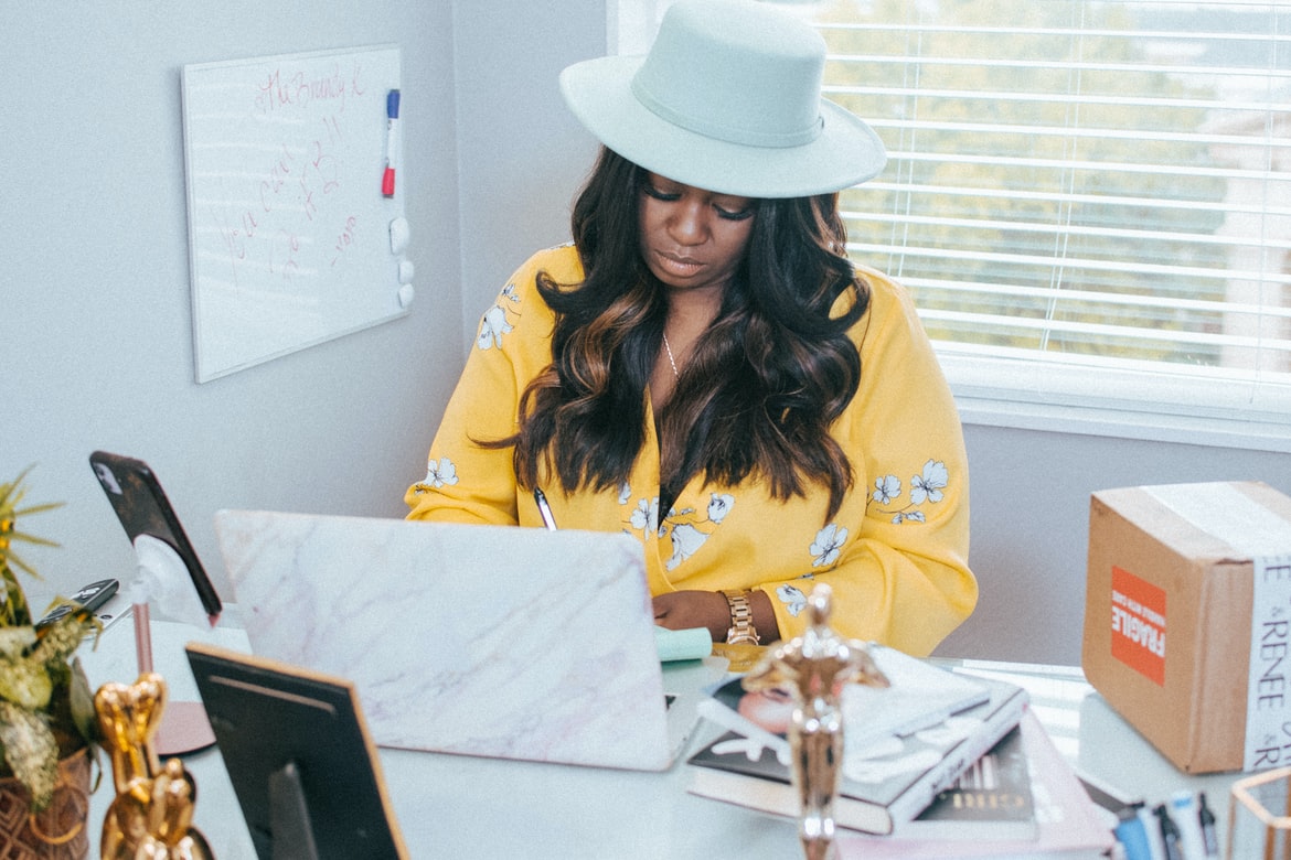 Fashionable woman works on a laptop.