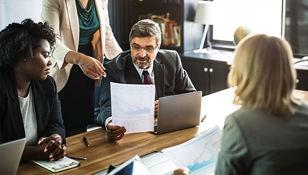 professionals in office, man in suit looking at report