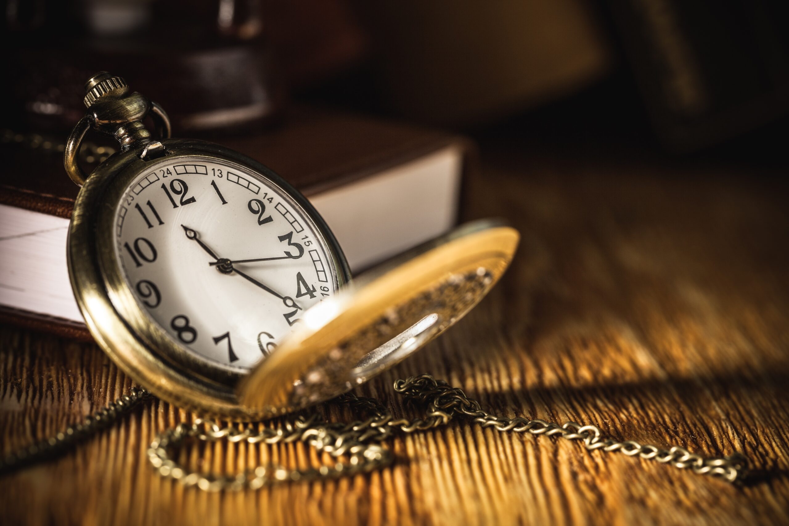 Vintage,Pocket,Watch,On,Wooden,Surface,Against,An,Old,Book