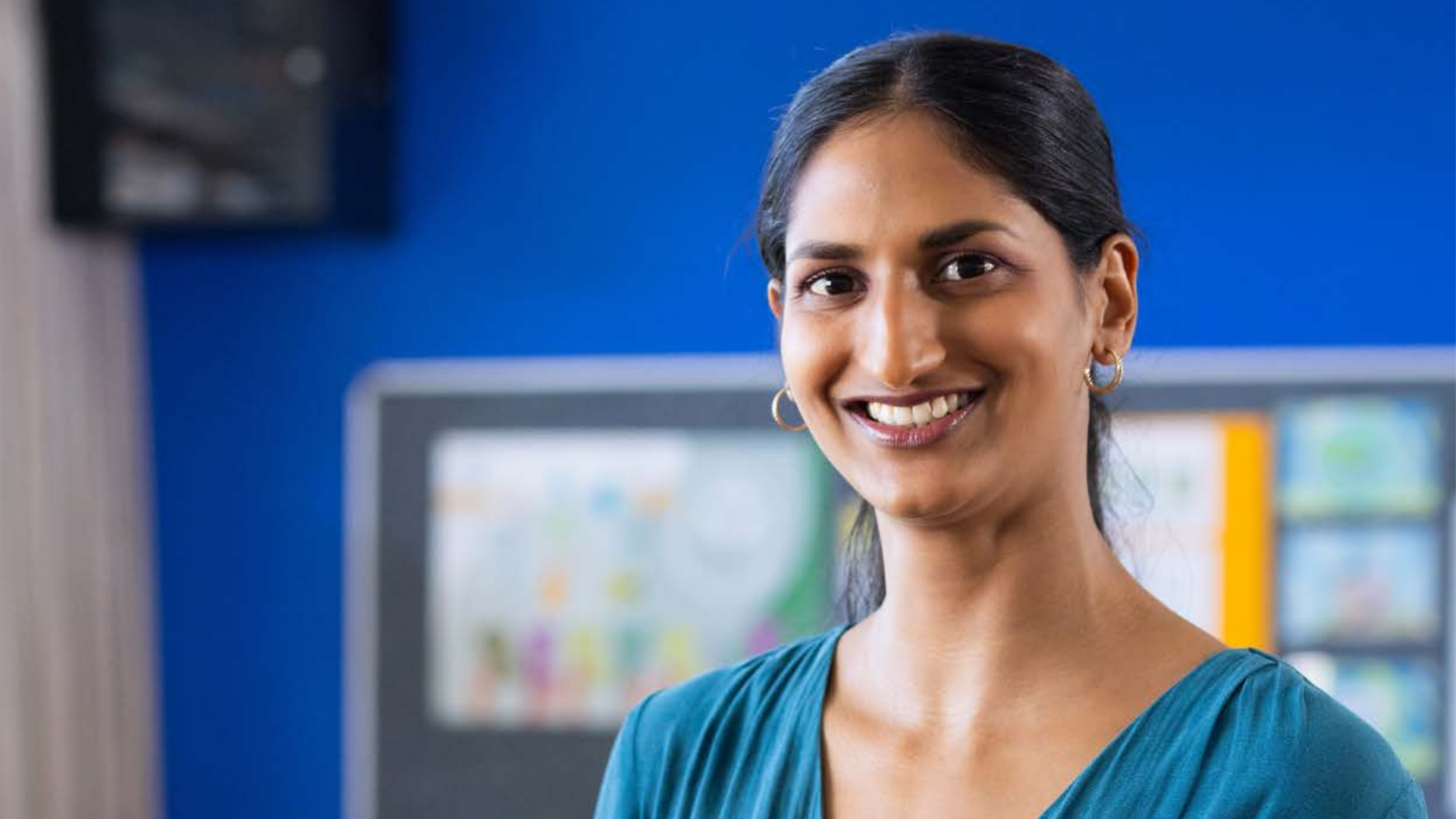 Female in a classroom smiling into camera