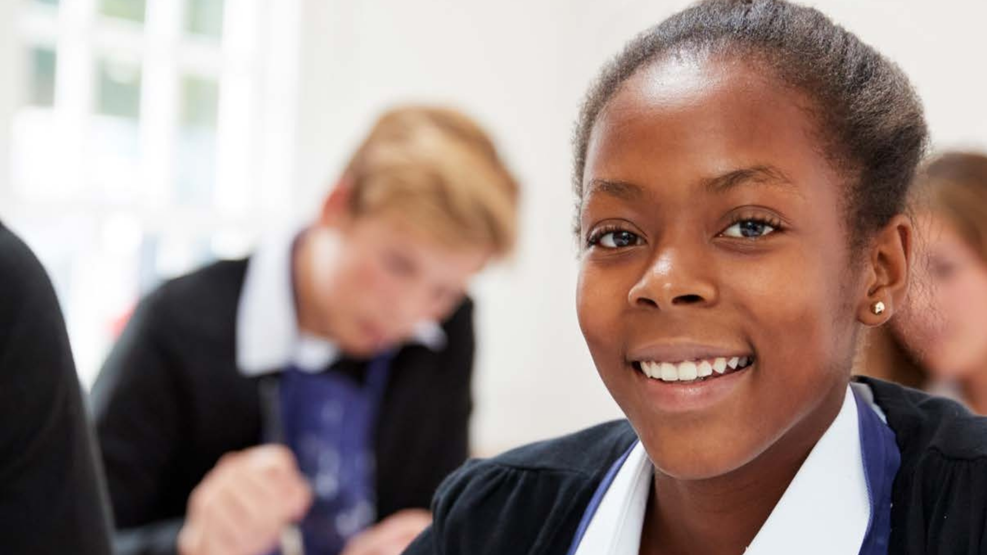 Pupil in school sitting in classroom smiling into camera