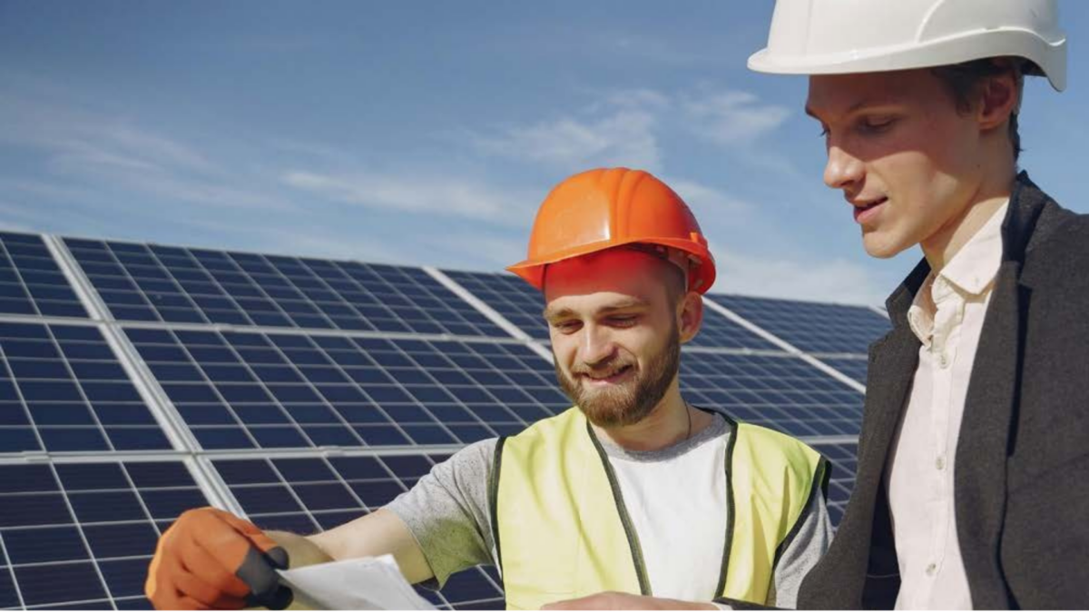 Two construction workers standing on a building site looking at plans
