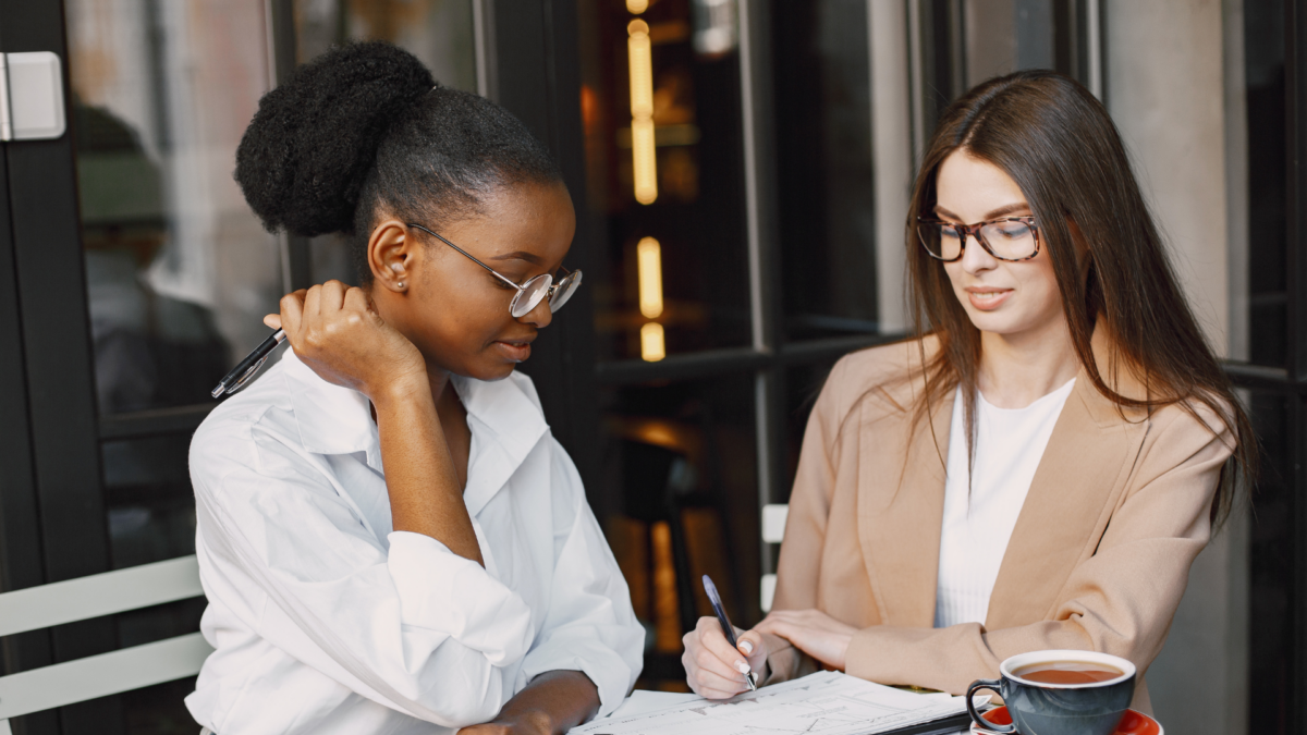 Two women sitting in an office discussing charity accounts